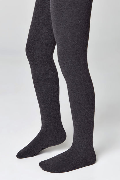 A pair of dark charcoal grey tights with ribbed texture worn on a person's legs against a plain white background.
