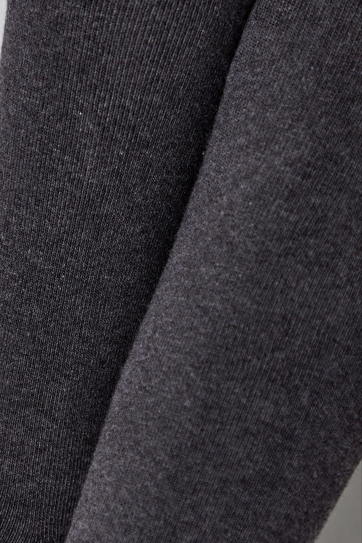 Close-up of charcoal gray fabric showing the textured knit pattern with visible vertical ribbing.
