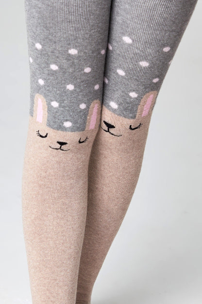 Children's tights featuring a grey polka dot pattern on the thighs and a beige lower section with a cute, sleepy-faced bunny character design on each knee.