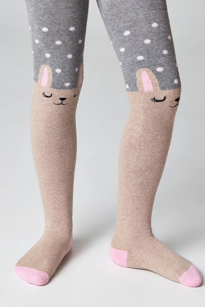 Children's tights featuring a grey top section with a white polka dot pattern and a tan bottom section designed with a sleeping bunny face on each knee, complete with light pink toe and heel accents.