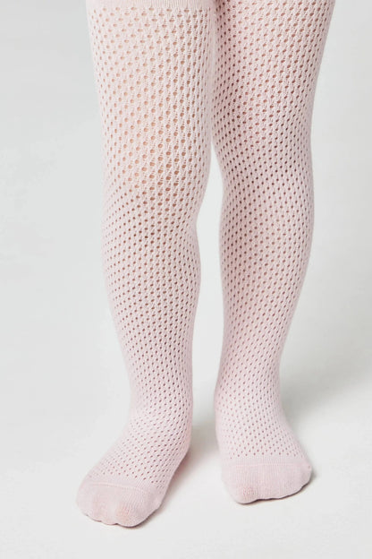 A pair of pale pink knit tights worn on legs, featuring an intricate, textured, openwork diamond pattern throughout.