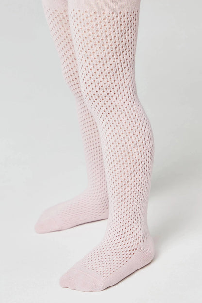 A pair of light pink tights with a textured, open-knit honeycomb pattern on the legs and solid fabric at the toes and heels, shown on a child's legs against a plain white background.