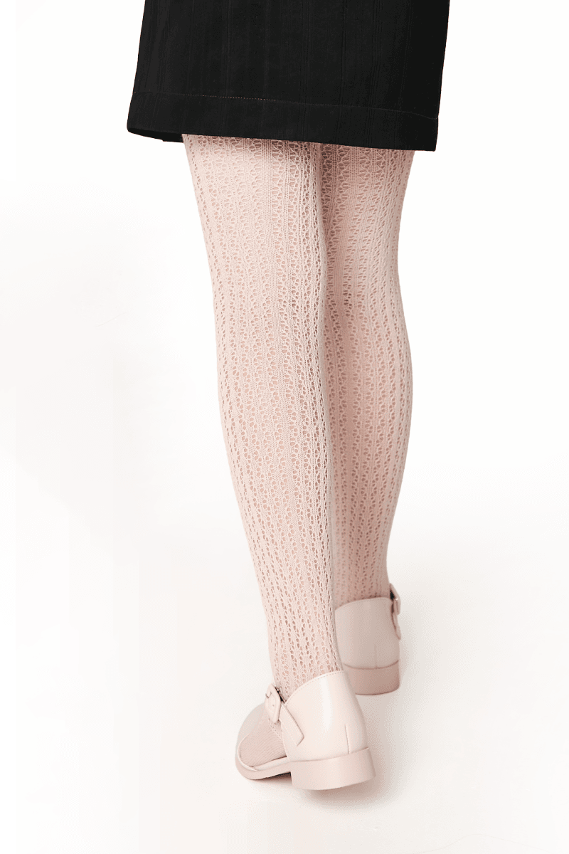 Light pink knit tights with a delicate openwork pattern paired with cream-colored flat shoes and a short black skirt.