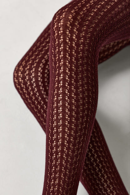 Burgundy tights featuring a delicate openwork vertical knit pattern on the legs.