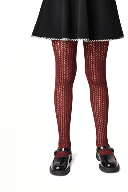 Burgundy patterned tights with a textured vertical knit design worn with a black skirt and shiny black buckled Mary Jane shoes.