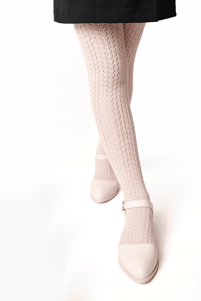 Light pink knit tights with a decorative textured pattern worn with light pink buckled Mary Jane shoes.