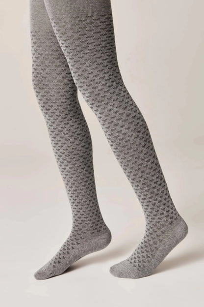 Grey tights featuring a repeating textured geometric heart pattern worn on legs against a plain light background.