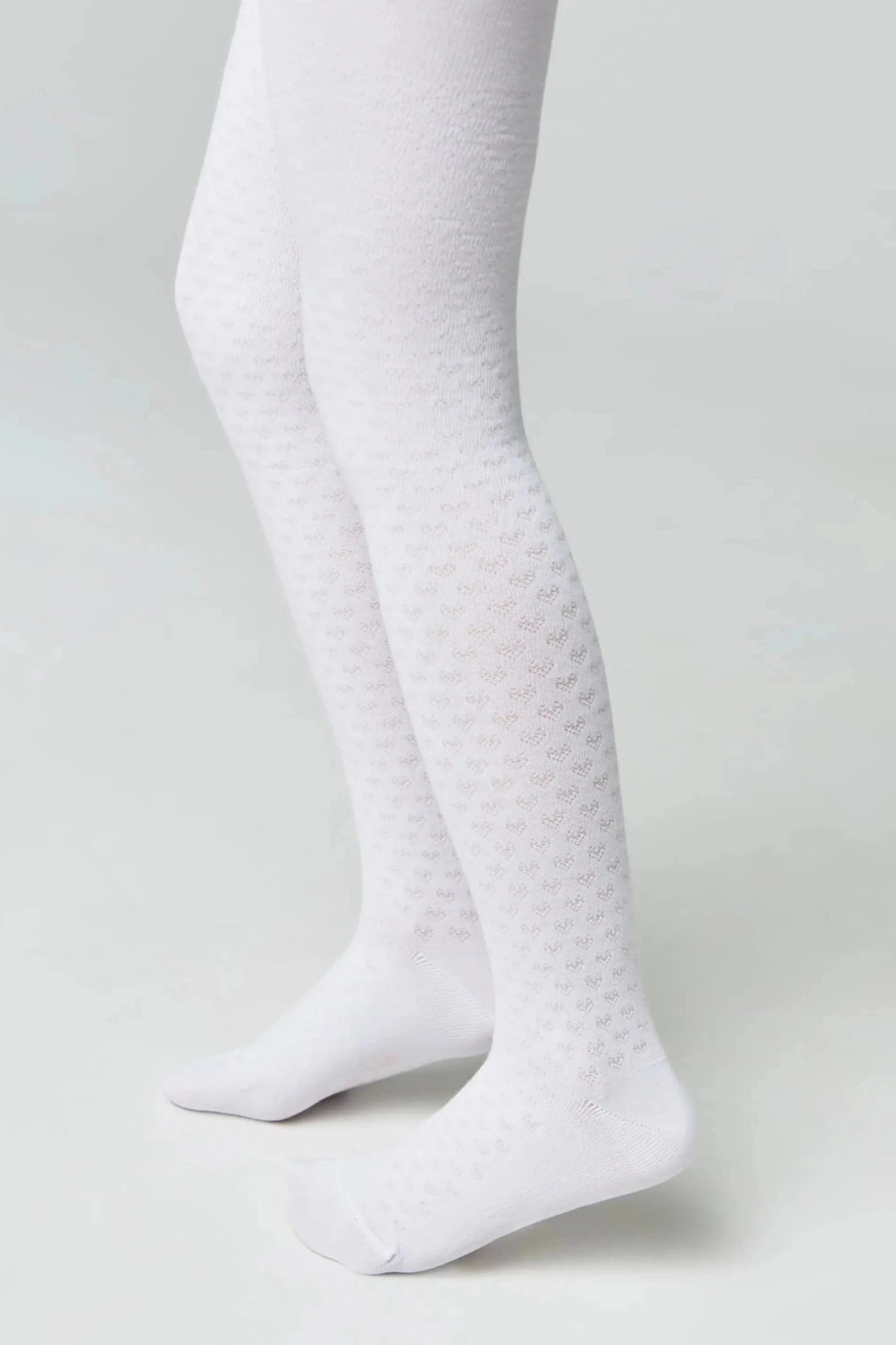 White tights for children featuring a textured, repeating heart pattern on the legs and solid white heels and toes.
