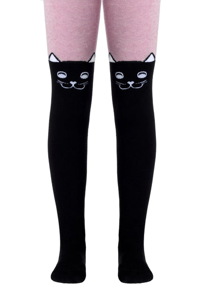 Over-the-knee socks feature a solid black leg and foot with a white cartoon cat face design positioned just above the knee, worn over light pink leggings.