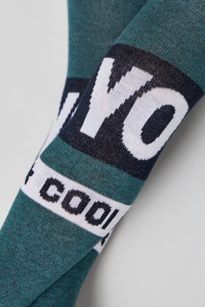 Close-up of teal fabric featuring horizontal bands of white text that reads YO and COOL against a dark blue background.