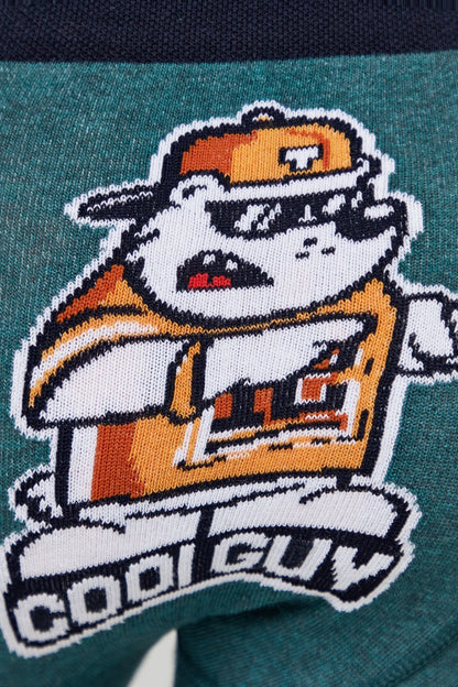 A close-up of a teal knit fabric featuring a cartoon bulldog wearing an orange and white cap and shirt, with the words COOL GUY embroidered in white below the figure.