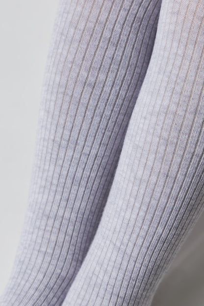 A close-up of two light purple, vertically ribbed stockings or tights against a plain white background.