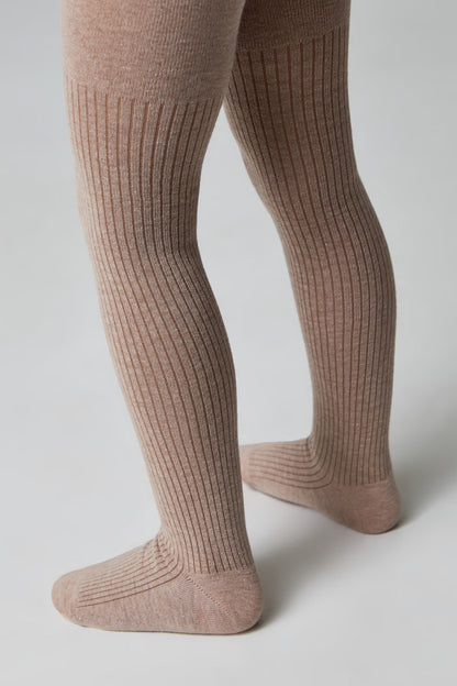 A pair of light brown ribbed tights worn on a child's legs against a plain white background.