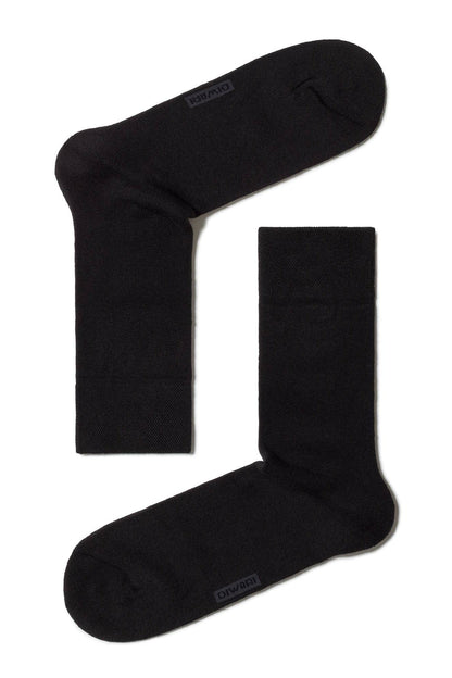 A pair of black crew socks with the brand name DIWARI embossed near the toe area, laid flat against a white background.