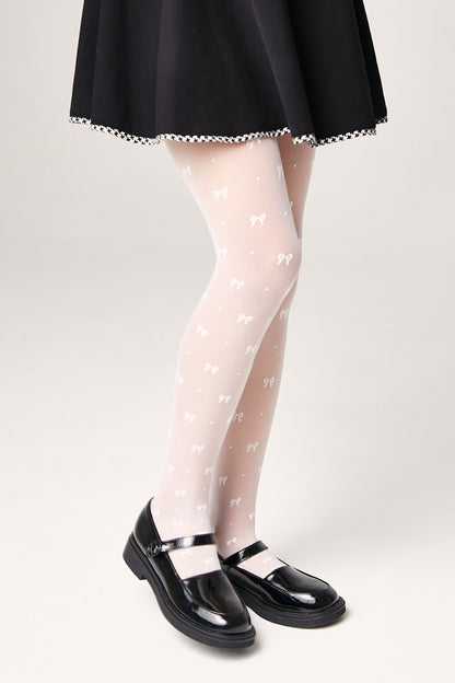 White sheer tights decorated with a small repeated bow pattern, worn with a black skirt and black mary jane shoes.