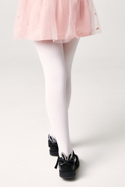 White tights worn with a pink skirt and black shoes decorated with rabbit ears and rhinestones.