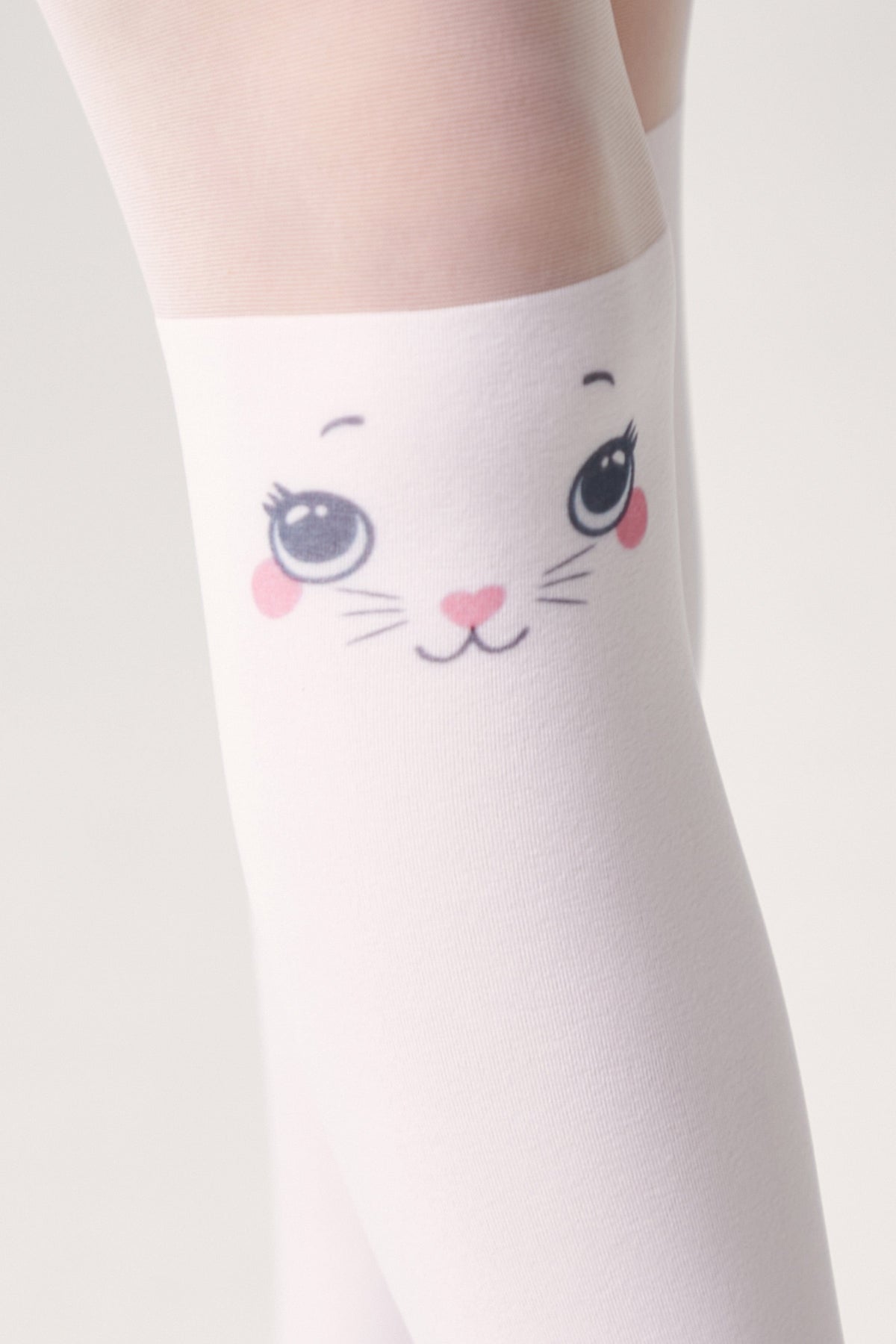 A close-up of white thigh-high stockings featuring a cute cartoon cat face print with large blue eyes, pink cheeks, and a small heart-shaped nose on the front.