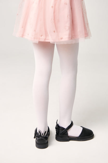 A pair of child's white tights paired with black Mary Jane shoes featuring a decorative bow and rabbit ears on the heel.