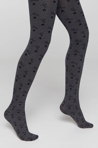 A pair of grey tights featuring a repeating pattern of black stars and the cursive word Stars against a light grey background, shown on legs against a neutral backdrop.