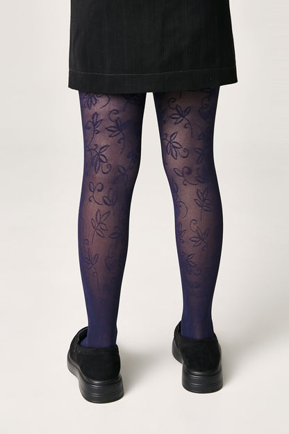 Blue patterned tights featuring a dark floral motif paired with a black skirt and black platform shoes.