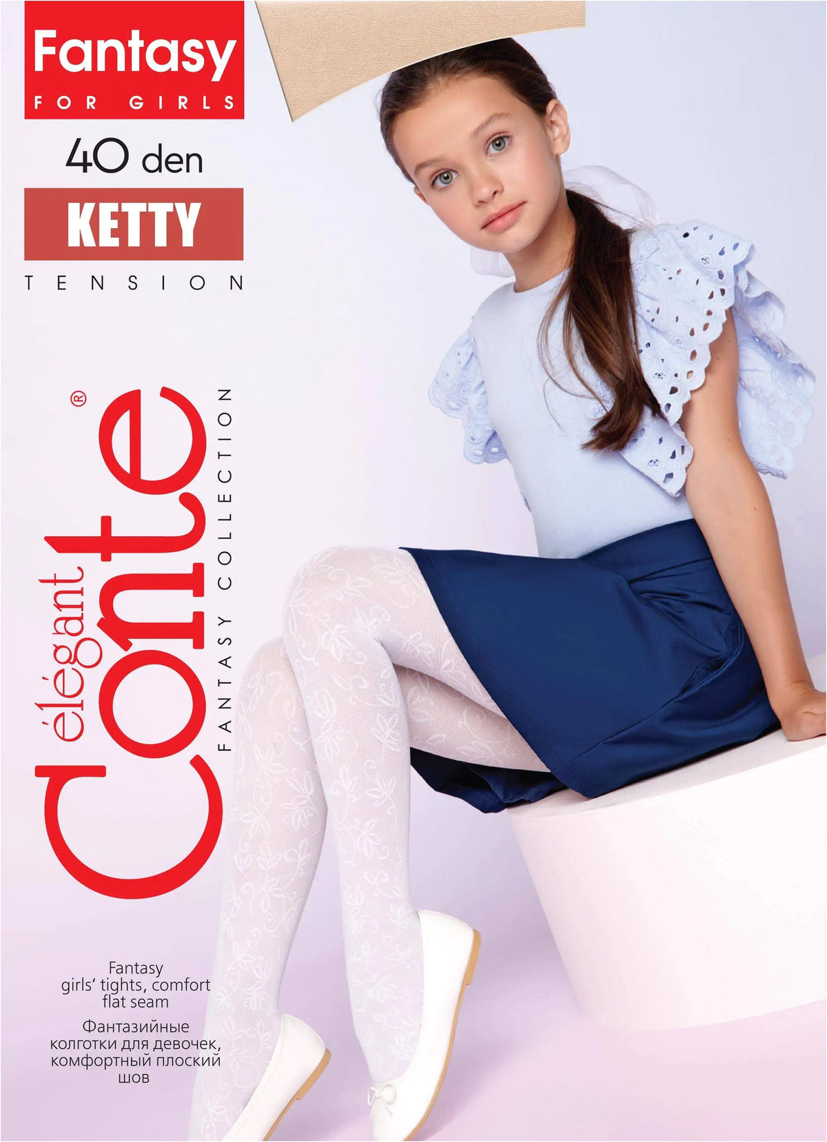 A young girl sits on a white cylindrical stool wearing white patterned tights, a navy blue skirt, and a light blue ruffled sleeve top.