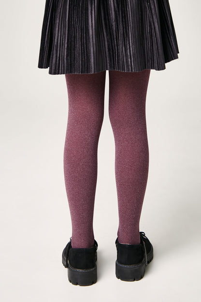 A pair of purple heathered tights worn by a child with a black pleated skirt and black flat shoes.