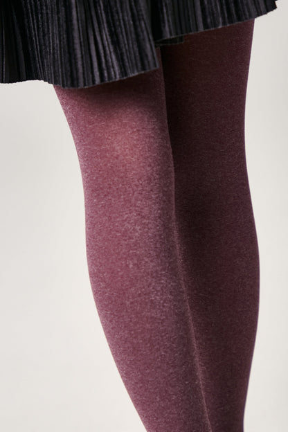 Burgundy opaque tights worn with a dark pleated skirt.