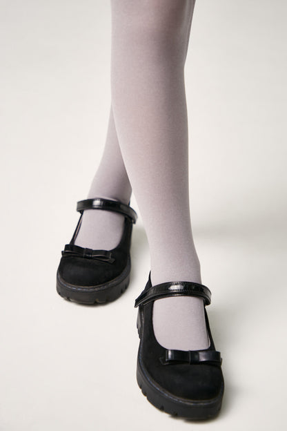 Black mary jane shoes with a strap and small bow accent worn with light grey tights.