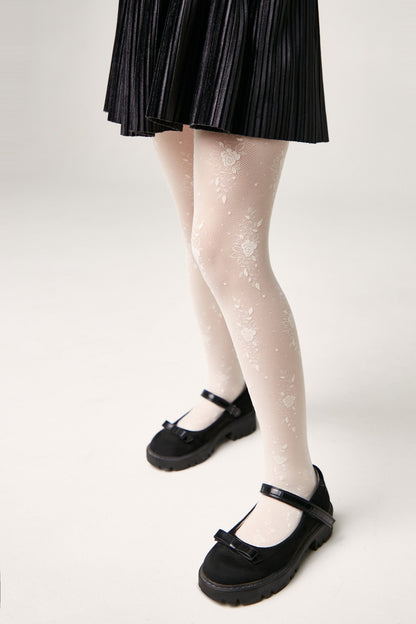 A pair of legs wearing white floral pattern tights and black Mary Jane shoes, viewed from the side against a plain white background.
