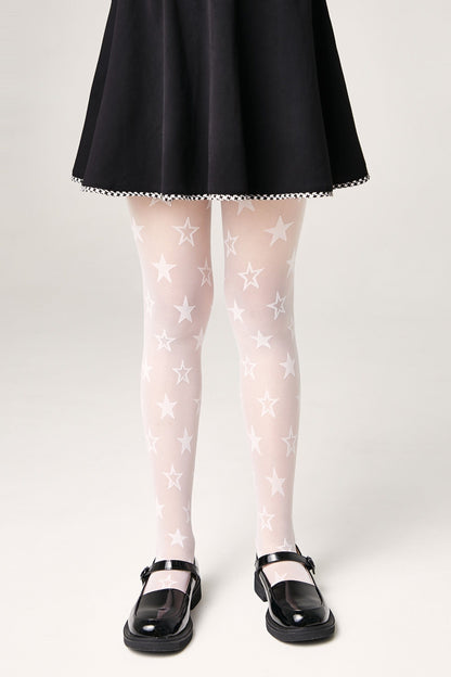 A person wears sheer white tights featuring a repeating pattern of five-pointed stars, paired with a black skirt and black Mary Jane shoes.