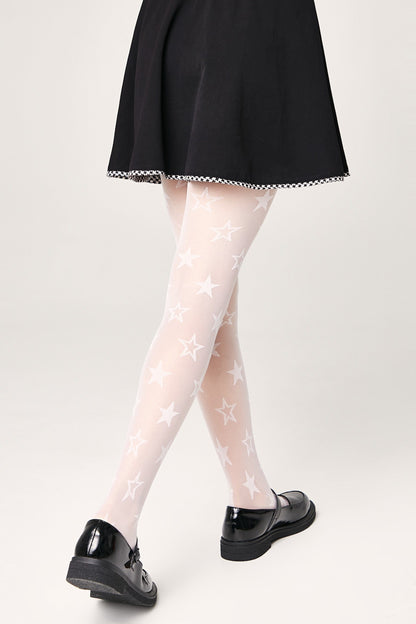 Sheer white tights featuring an all-over pattern of white stars, worn with a black skirt and black mary jane shoes.
