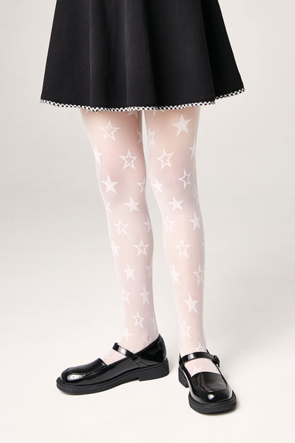 White sheer tights decorated with repeating white star patterns are paired with a black skirt and black Mary Jane shoes.