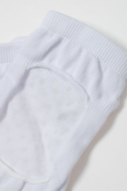 A close-up of a white sock showing the textured, reinforced arch support area with a rounded knit pattern on a plain white background.