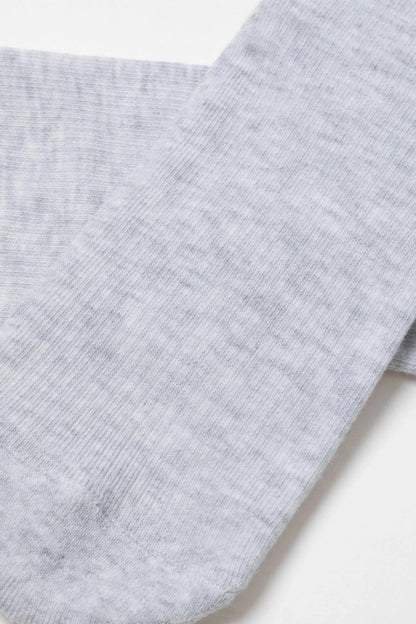 A close-up of a light grey heathered knit sock featuring a visible vertical ribbed texture.
