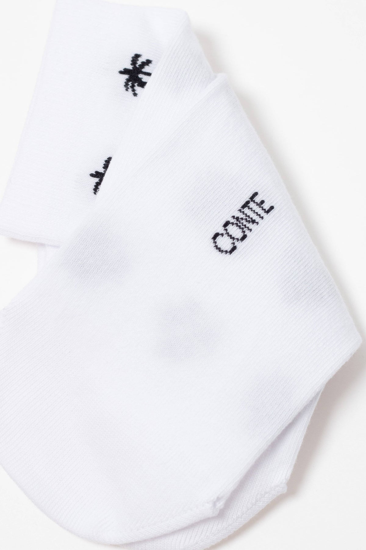 A pair of folded white ankle socks featuring a black palm tree icon and the word CONTE printed in black text.