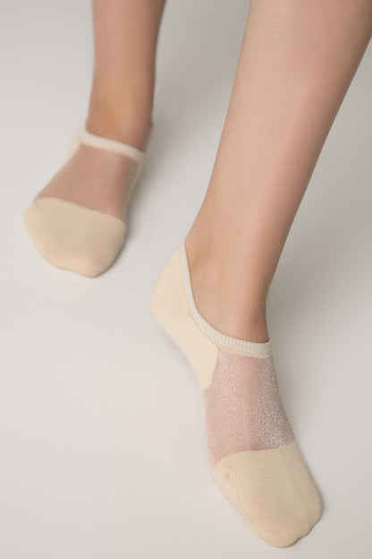 A pair of beige low-cut no-show socks worn on a person's feet, featuring a sheer shimmering panel across the top of the foot and a solid-colored toe and heel section.