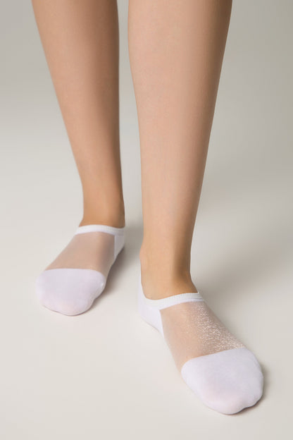 A pair of white low-cut ankle socks with a sheer, shimmering mesh top panel worn on a person's feet against a plain light background.