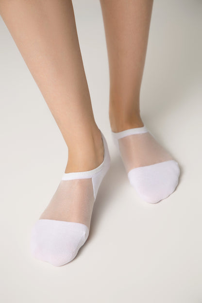 A pair of white low-cut no-show socks worn on a person's feet against a plain light background.