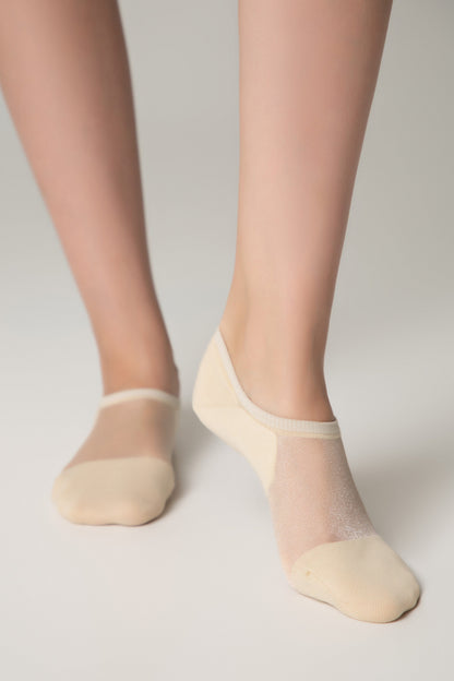 Beige no-show socks with a sheer, shimmering mesh top and solid fabric toe and heel sections worn on a pair of legs against a plain white background.