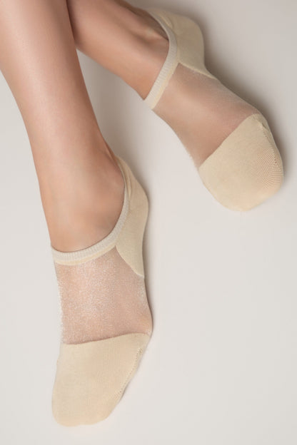 A pair of beige low-cut socks with sheer mesh fabric on the top of the foot and solid knit material on the toes and heel, shown on a person's feet against a light background.