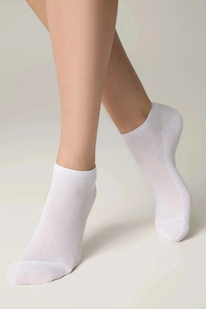 A pair of white ankle socks worn on the feet against a plain light background.