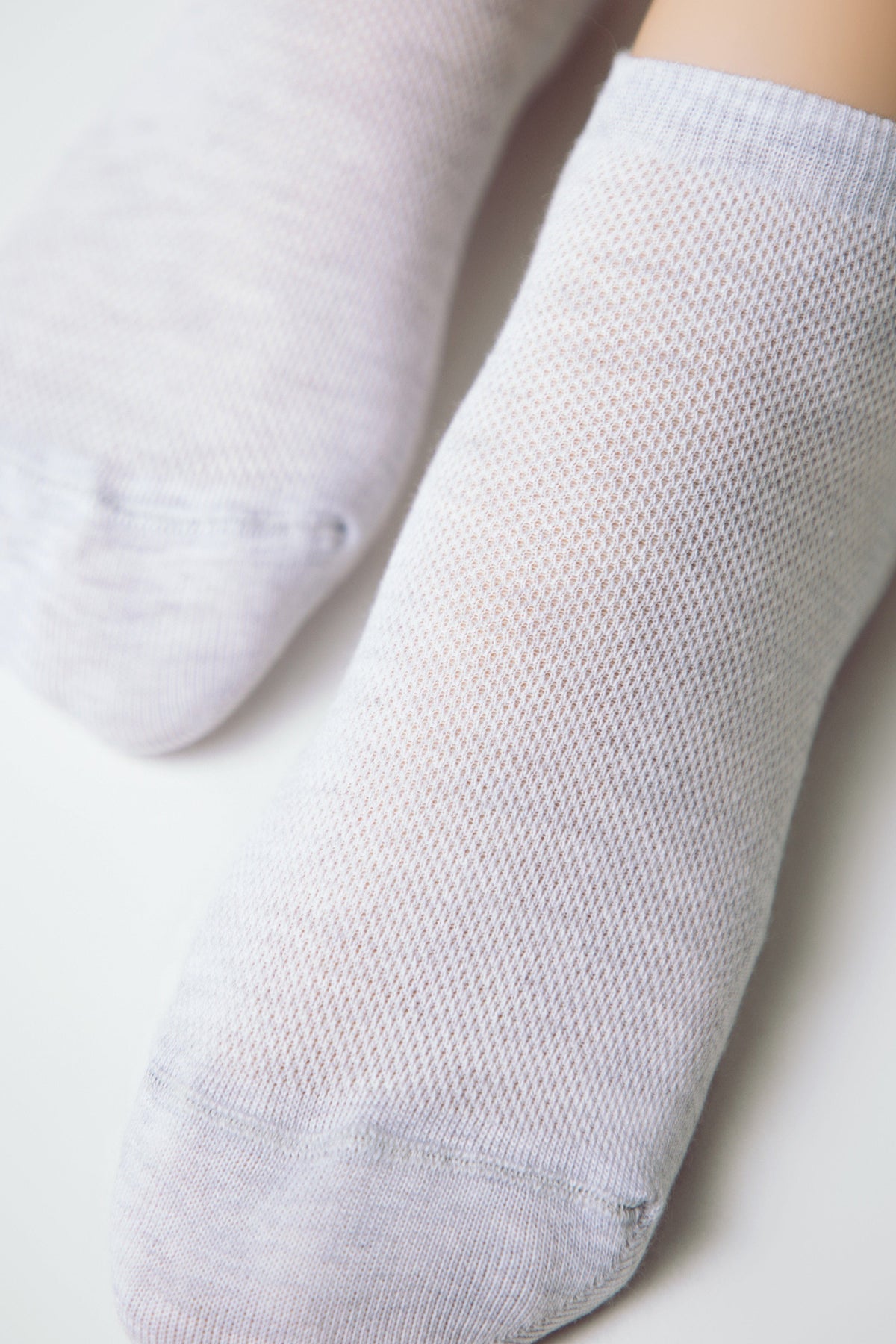 A pair of light gray mesh socks are shown from a top-down view on a plain white background.