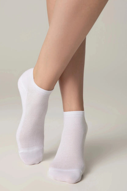 A pair of white ankle socks worn on feet against a neutral background.