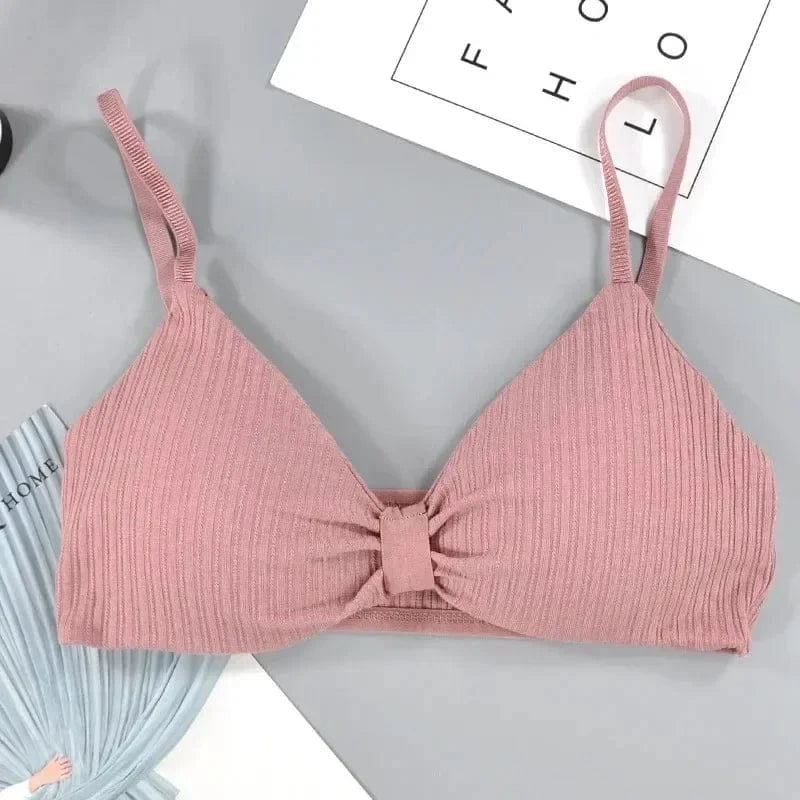A mauve ribbed bralette with adjustable spaghetti straps and a small gathered detail in the center of the chest, laid flat on a grey background.