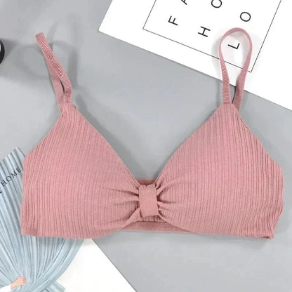 A mauve ribbed bralette with adjustable spaghetti straps and a small gathered detail in the center of the chest, laid flat on a grey background.