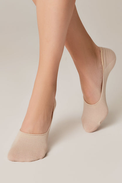Beige no-show liner socks worn on feet against a solid light background.