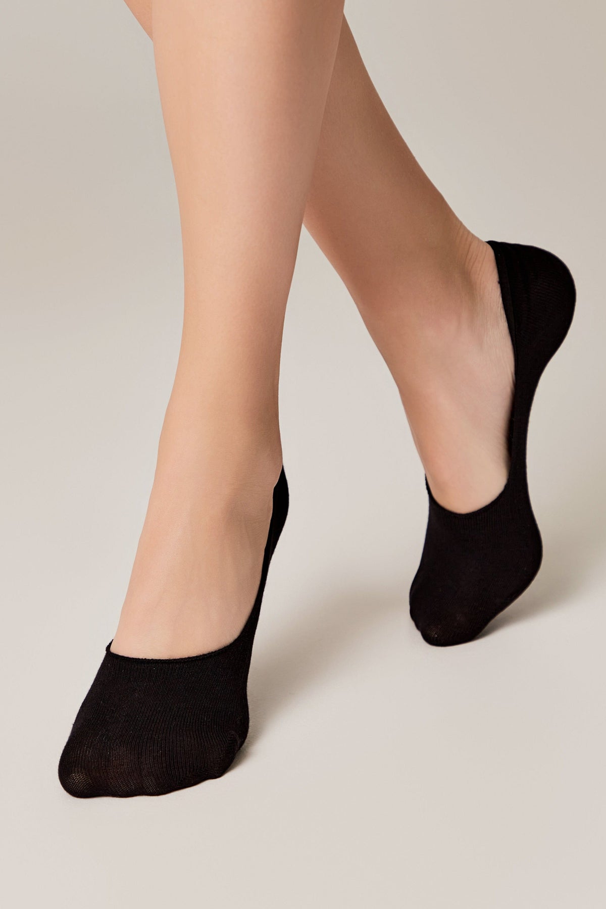 Black no-show liner socks worn on feet against a neutral background.