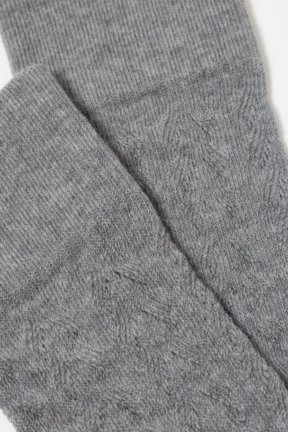 A close-up view shows folded grey fabric with a fine, textured knit pattern.