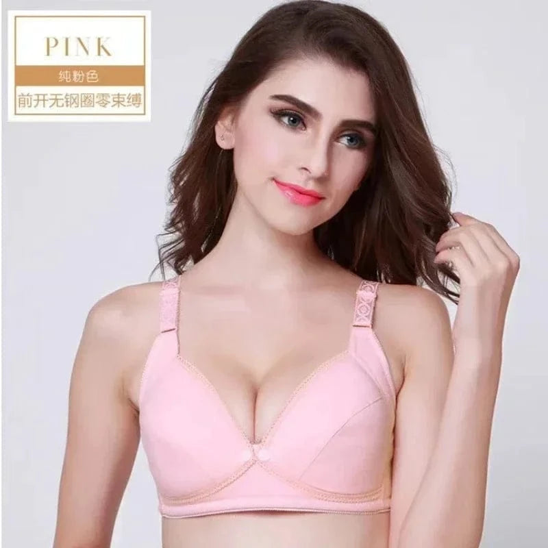 A light pink front-closure bra with textured straps is worn by a woman against a plain white background.