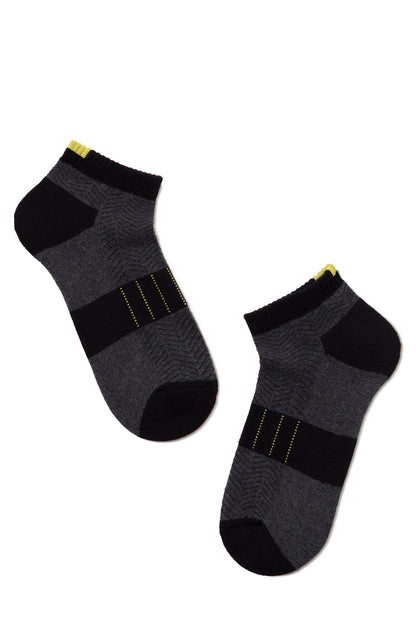 A pair of ankle-length socks in black and charcoal gray featuring a herringbone pattern, horizontal stripes, and small yellow accents at the cuffs and mid-foot.